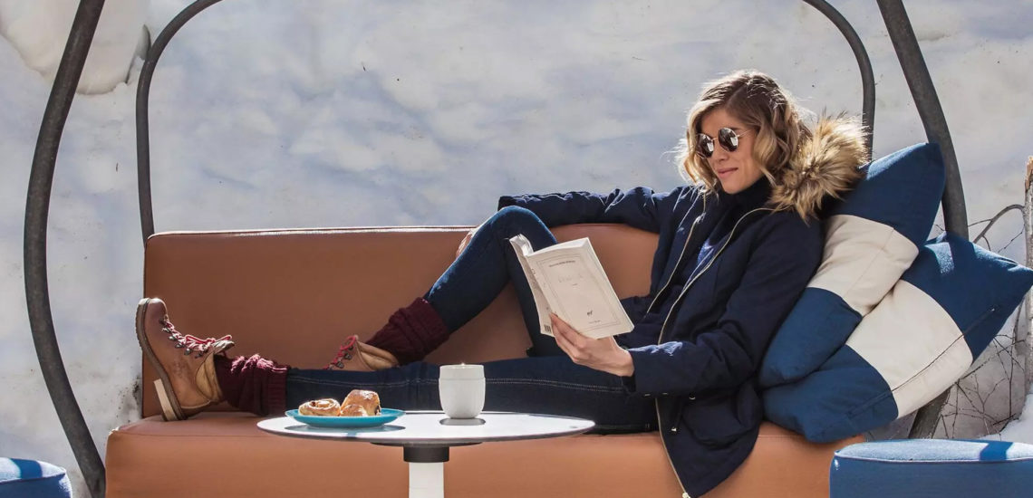 Club Med Peisey - Vallandry, en France - Une femme est assis sur un banc et lis un livre, au Snow Motion