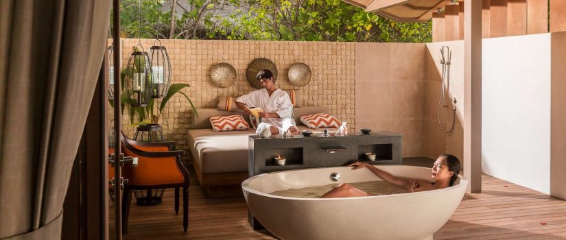 Club Med Villas de Finolhu, aux Maldives - Un couple profite de la salle de bain extérieure privée de leur location.