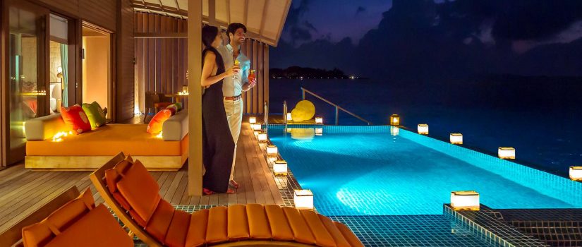 Club Med Villas de Finolhu, aux Maldives - Un couple devant leurs piscine privée, en soirée.