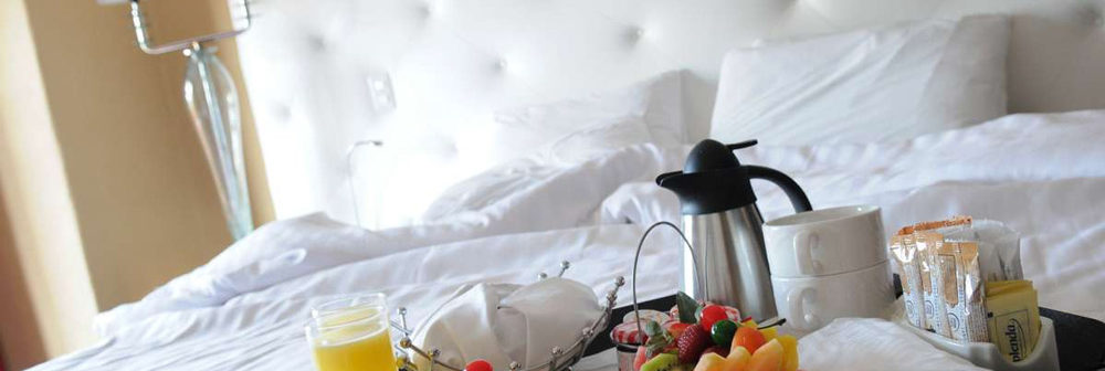 Club Med  Ixtapa Pacific, Mexique - Un petit déjeuner est déposé sur un lit blanc, avec café 