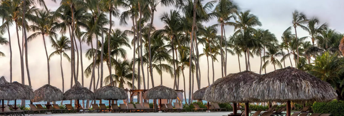 Club Med Punta Cana, en République Dominicaine - Image au coucher de soleil d'une piscine et de ses cabanas 
