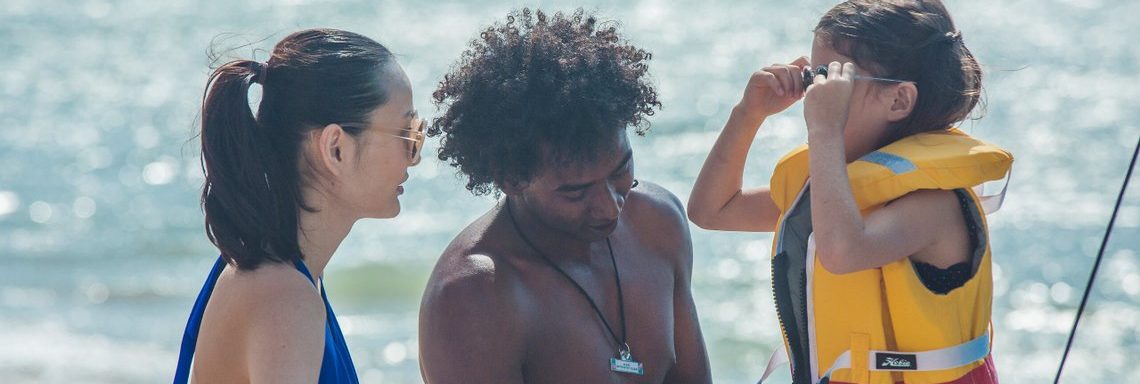 Club Med Miches Playa Esmeralda, en République Dominicaine - Un GO mettant un gilet de sauvetage à un enfant