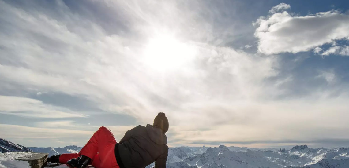 Club Med Val Thorens Sensations, France - Un homme est couché sur le flanc d'une montagne en habit d'hiver